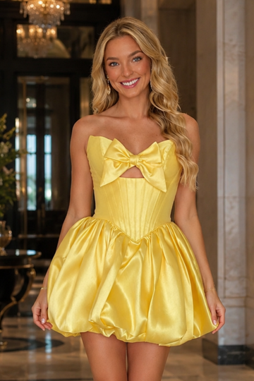Yellow satin A-line corset homecoming dress with puff sleeves and bow.